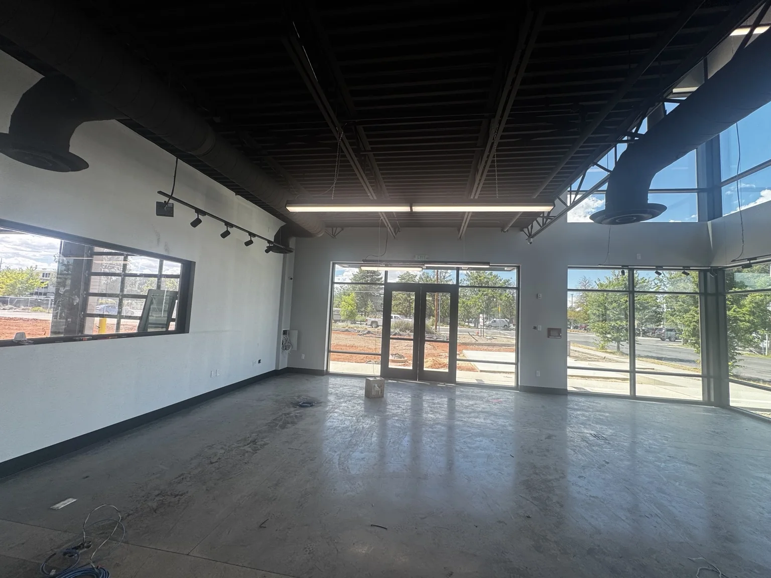 Large Big O Tire showroom with full-height front windows, clean white walls, and dark overhead finishes