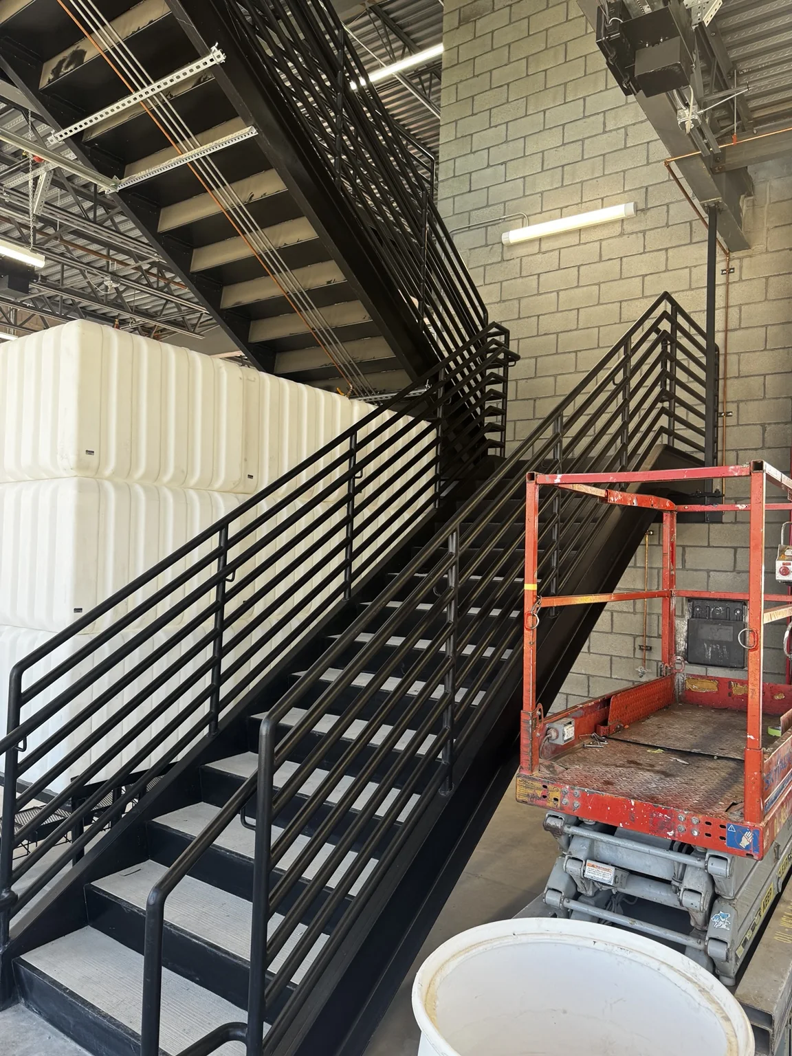 Big O Tire warehouse staircase with custom black-painted steel railings and a finished industrial stair structure