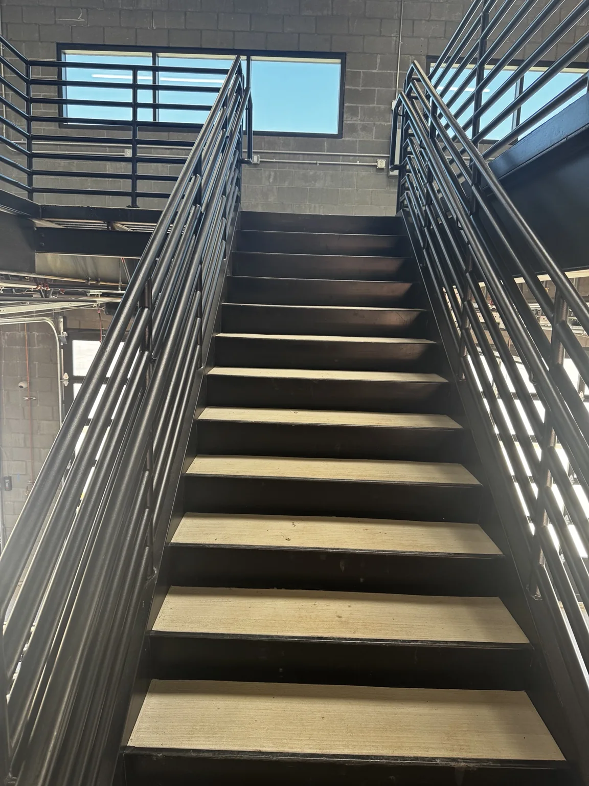 Black-painted service-area stairway and metal handrails at the Big O Tire commercial facility
