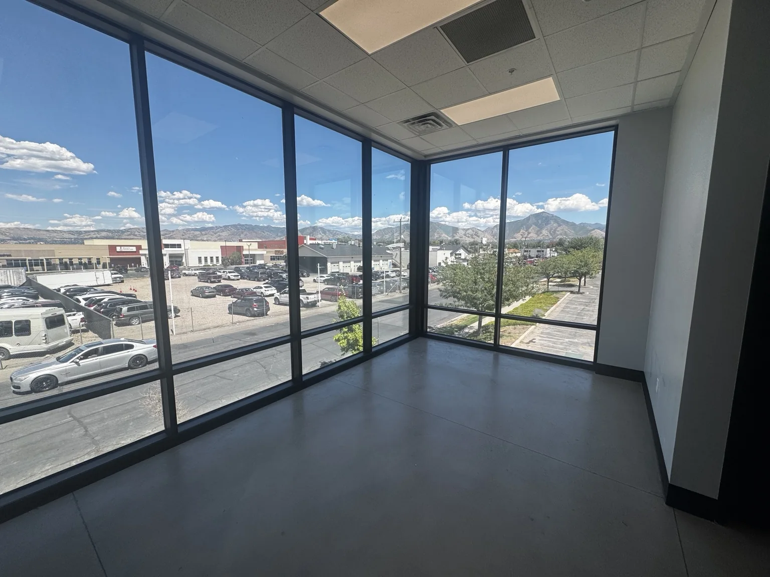 Finished corner office at Big O Tire with clean painted walls, dark trim, and expansive mountain-view windows