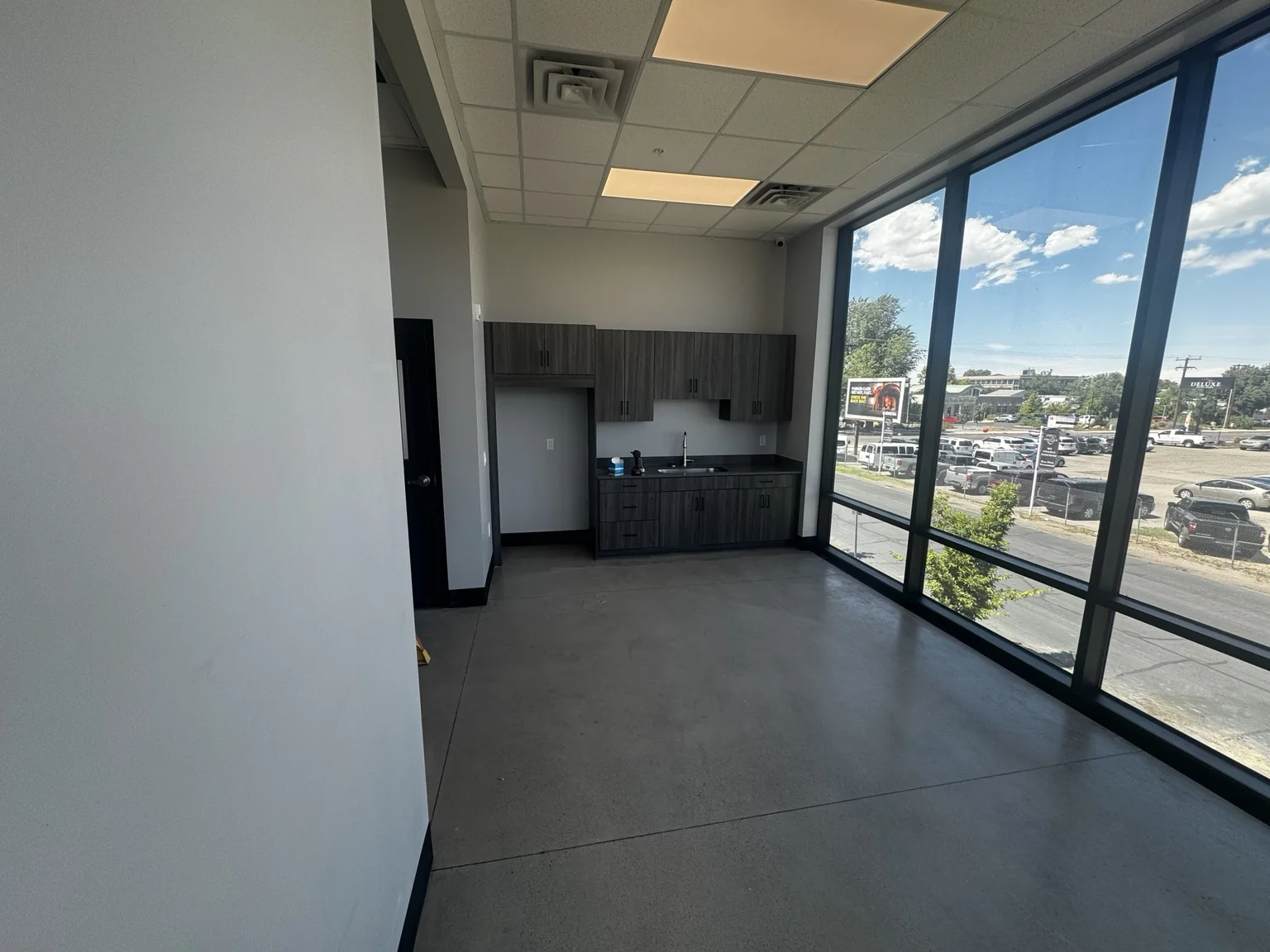 Big O Tire employee breakroom with newly painted walls, dark cabinetry, and floor-to-ceiling windows
