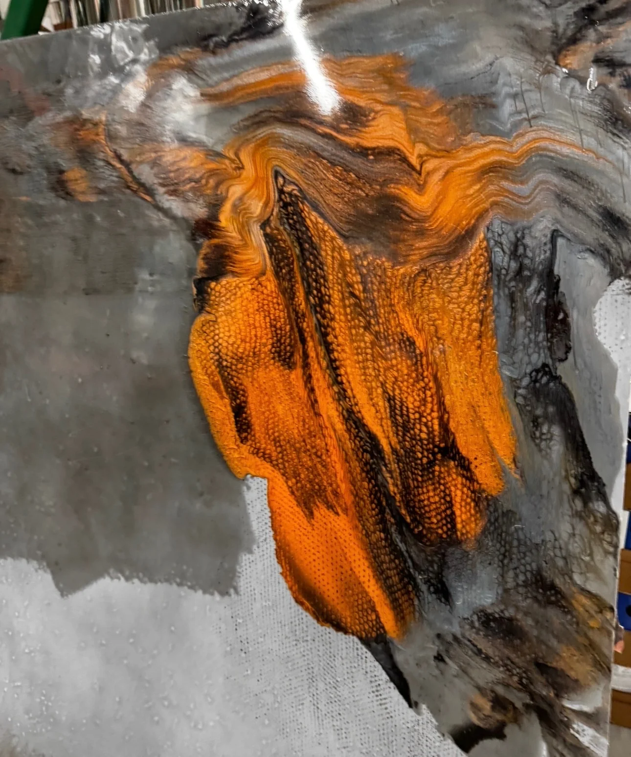 High-gloss metallic epoxy floor sample with flowing copper, charcoal, silver, and black decorative pigments